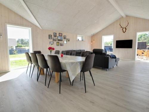 a dining room with a table and chairs and a couch at Holiday Home Tahvo - 3-3km from the sea by Interhome in Rømø Kirkeby