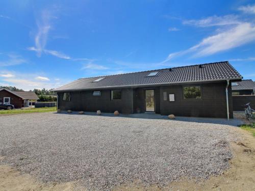 a house with a gravel driveway in front of it at Holiday Home Tahvo - 3-3km from the sea by Interhome in Rømø Kirkeby