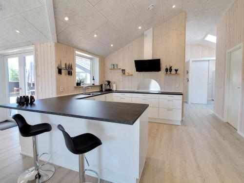 a kitchen with a counter and two bar stools at Holiday Home Tahvo - 3-3km from the sea by Interhome in Rømø Kirkeby