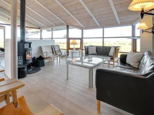 a living room with couches and a fireplace at Holiday Home Alim - 300m from the sea in Western Jutland by Interhome in Lakolk