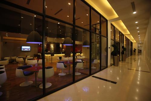 a lobby with tables and chairs in a building at Keys Select by Lemon Tree Hotels, Whitefield, Bengaluru in Bengaluru