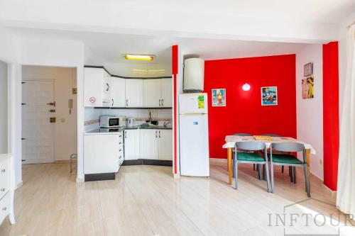 カルプにあるInftour Paola 5 Apartamentoの赤い壁のキッチン(テーブル付)