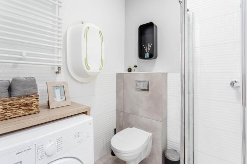 a small bathroom with a toilet and a shower at Chill Apartments Airport Ursynów in Warsaw