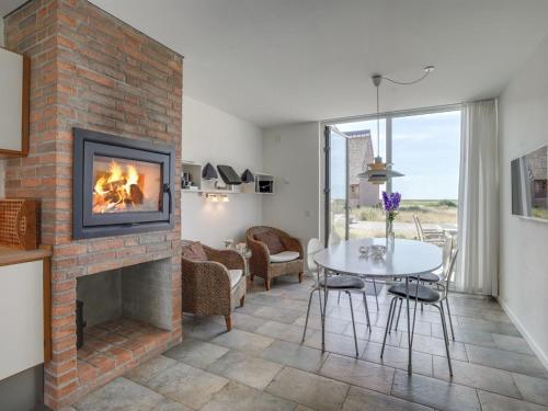 a living room with a fireplace and a table at Apartment Helgo - 250m from the sea in Western Jutland by Interhome in Sønderby