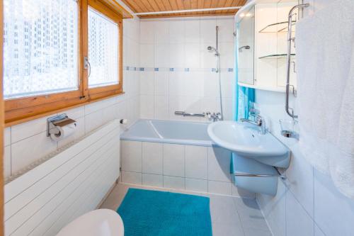 a bathroom with a blue sink and a tub at Chalet Sven & Marc Grächen, Niedergrächen Vallis in Sankt Niklaus