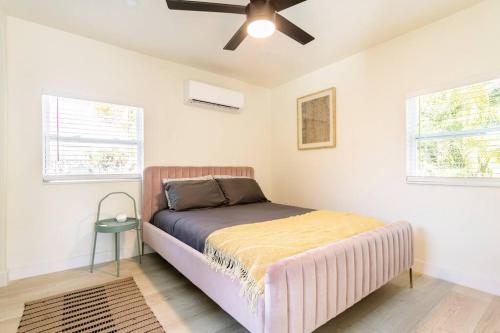 um quarto com uma cama e uma ventoinha de tecto em The Pastel Home em Fort Lauderdale