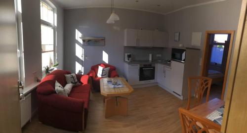 sala de estar con sofá rojo y mesa en Haus Breslau en Borkum