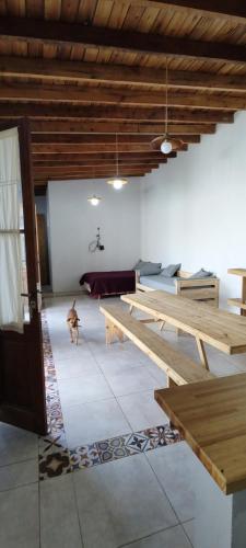 una habitación con mesas de madera y un perro. en Malvinas 90 en Chascomús