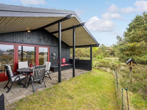 a barn with a table and chairs on a patio at Holiday Home Kathaline - 3-4km from the sea in Western Jutland by Interhome in Bolilmark