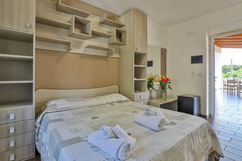 a bedroom with a large bed with towels on it at Il Pineto Paestum Food & Rooms in Paestum