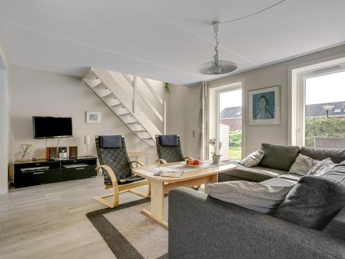 een woonkamer met een bank en een tafel bij Apartment Palni - 2-3km from the sea in Western Jutland by Interhome in Sønderby