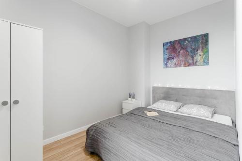 a bedroom with a bed and a painting on the wall at Chill Apartments Airport Ursynów in Warsaw