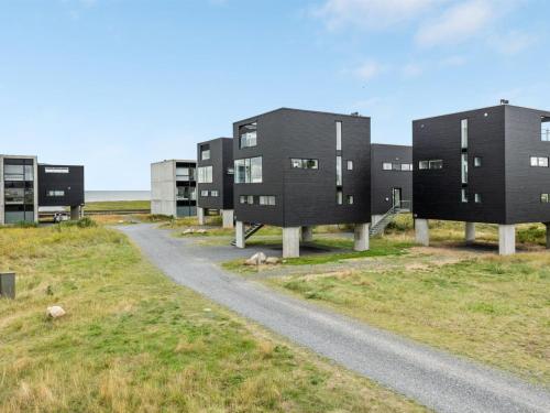 a row of black buildings on a road at Holiday Home Leto - 2km from the sea by Interhome in Havneby