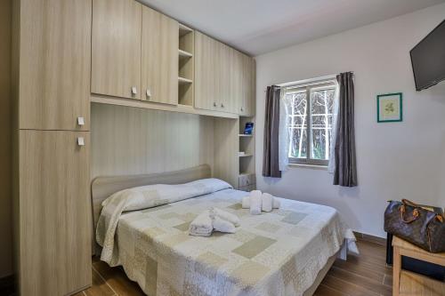 a bedroom with a bed with two towels on it at Il Pineto Paestum Food & Rooms in Paestum