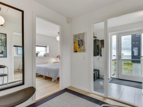 a room with white walls and a bedroom with a bed at Holiday Home Leto - 2km from the sea by Interhome in Havneby