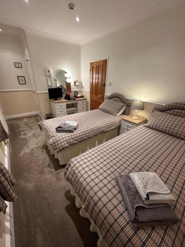 a hotel room with three beds and a mirror at Vane House in Osmotherley