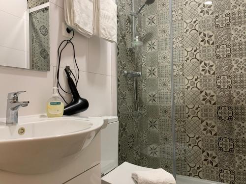 ein Bad mit einem Waschbecken und einer Dusche in der Unterkunft Discovery Apartment Estrela in Lissabon