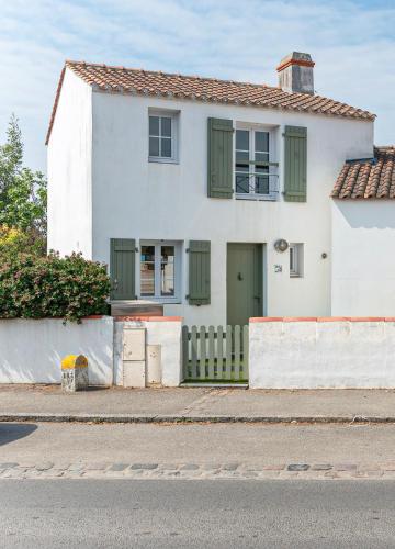 une maison blanche avec une porte verte et une clôture dans l'établissement Maison avec Jardin proche des plages, à Noirmoutier-en-l'lle