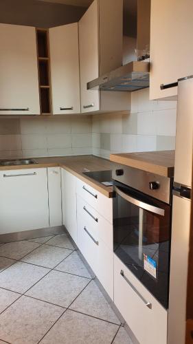 a kitchen with white cabinets and a stove top oven at Il Chicco apartment in Lamporecchio
