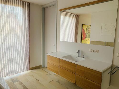 a bathroom with a sink and a mirror and a window at Trilogie am See Wohnung Schmetterling in Stetten