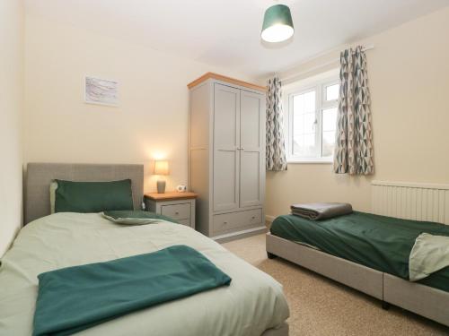 a bedroom with two beds and a window at Primrose Cottage in Westbury