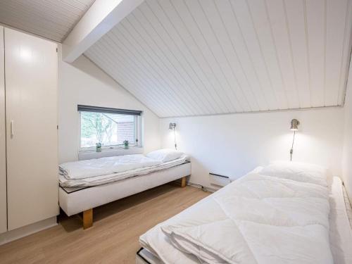 two beds in a white room with a window at Holiday home Oksbøl LVII in Oksbøl