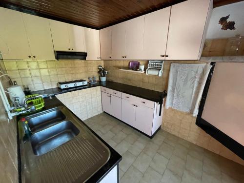 a small kitchen with a sink and a refrigerator at Nionas Cheerful House in Píso Meriá