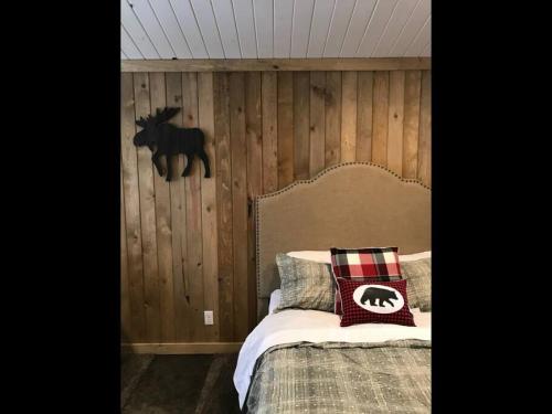 a bedroom with a bed with a wooden wall at Single Cabin Unit 3 in Rea