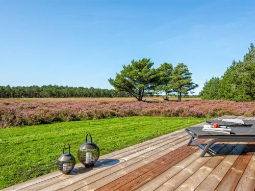 a wooden deck with a picnic table and a field at Holiday Home Tea - 2-7km from the sea in Western Jutland by Interhome in Bolilmark