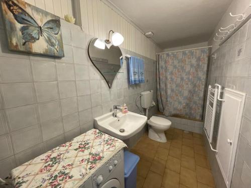 a small bathroom with a sink and a toilet at Nionas Cheerful House in Píso Meriá