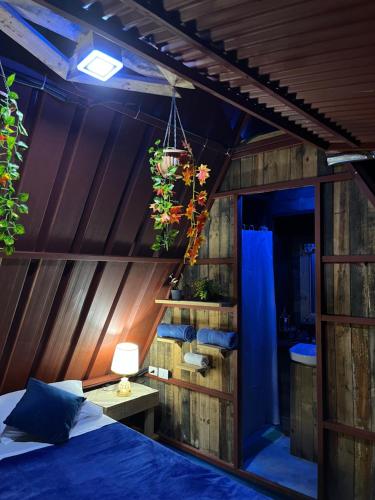 ein Schlafzimmer mit einem Bett in einem Zimmer mit Holzwänden in der Unterkunft Tinyhouse samaná 