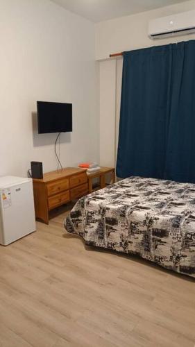 1 dormitorio con 1 cama y TV en TANGO ARGENTINO en Buenos Aires