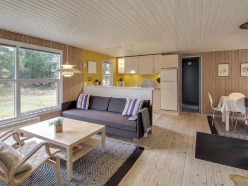een woonkamer met een bank en een tafel bij Holiday Home Dika - 1km from the sea in Western Jutland by Interhome in Vejers Strand