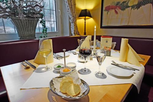 a table with glasses of wine and bread on it at Landidyll Hotel Haus Hochstein in Wenholthausen