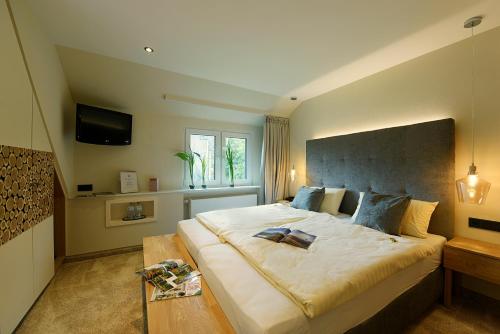 a large bedroom with a large bed and a table at Landidyll Hotel Haus Hochstein in Wenholthausen