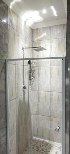 a shower with a glass door in a bathroom at Cheers in Evander