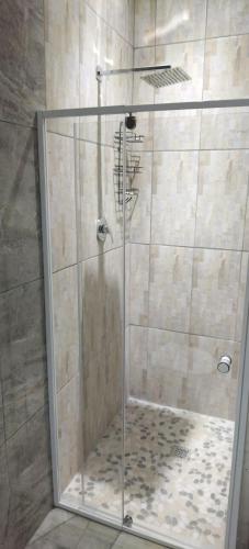 a shower with a glass door in a bathroom at Cheers in Evander