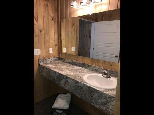 a bathroom with a sink and a mirror at Family Cabin Unit 10 in Rea