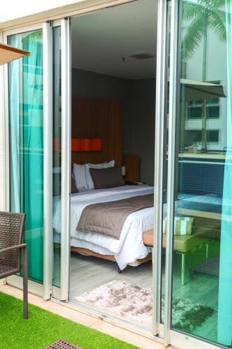 a bedroom with a bed and sliding glass doors at Jade Hotel Brasília in Brasilia