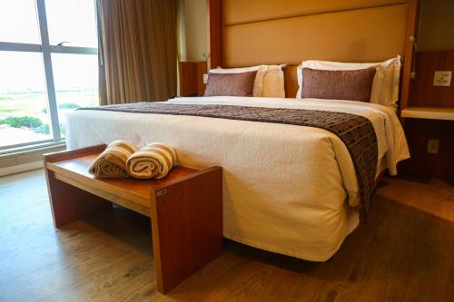 a bedroom with a large bed with towels on a table at Jade Hotel Brasília in Brasilia