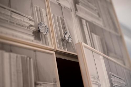 a cabinet with glass doors with flowers in it at Landidyll Hotel Haus Hochstein in Wenholthausen