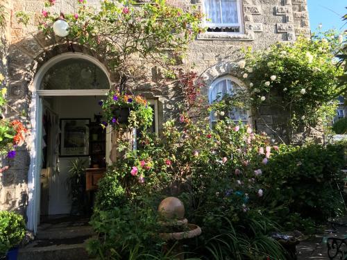 an entrance to a stone house with flowers at Penzance Seaside studios in Penzance