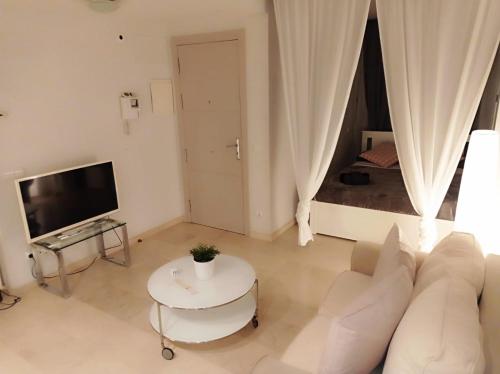 een woonkamer met een witte bank en een tafel bij Loft Apartment Sagrada Familia in Barcelona