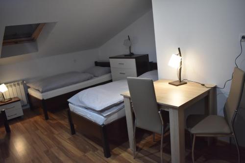 KozłówekにあるAgrowilla Kozłówekのデスク、ベッド、テーブルが備わる小さな客室です。