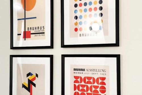 a group of four framed posters on a wall at Dimora Roè in Monticello d'Alba