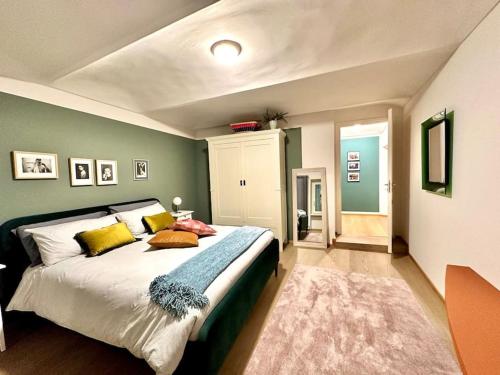 een slaapkamer met een groot bed en groene muren bij Dimora Roè in Monticello d'Alba