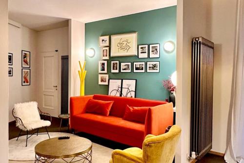 a living room with an orange couch and a table at Dimora Roè in Monticello d'Alba