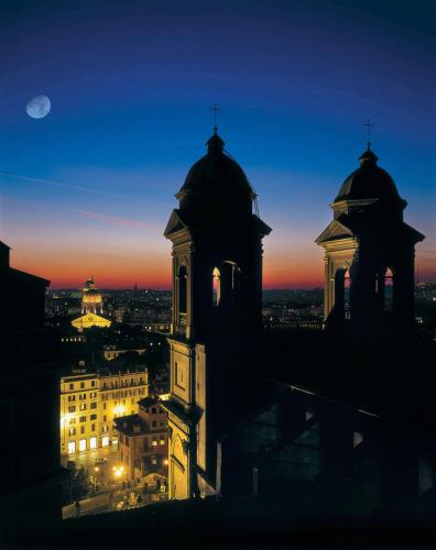 a building with a clock tower at night at Hassler Roma in Rome