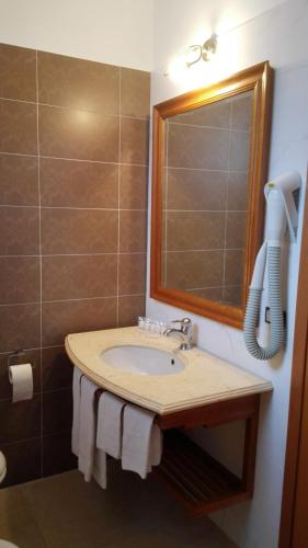 a bathroom with a sink and a phone on the wall at Albergo Del Pino in Cercola