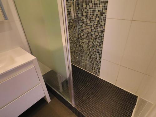 une douche avec une porte vitrée dans une salle de bain dans l'établissement 38m² Face à la mer, clim, WIFI, parking, piscine - 2⭐ - FR-1-472A-133, à Sète